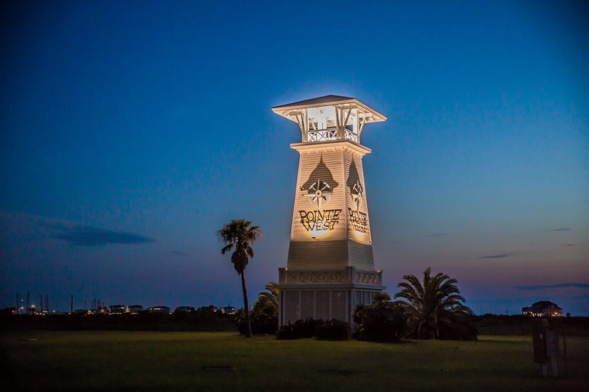 The Pointe West lighthouse tower lit up at night
