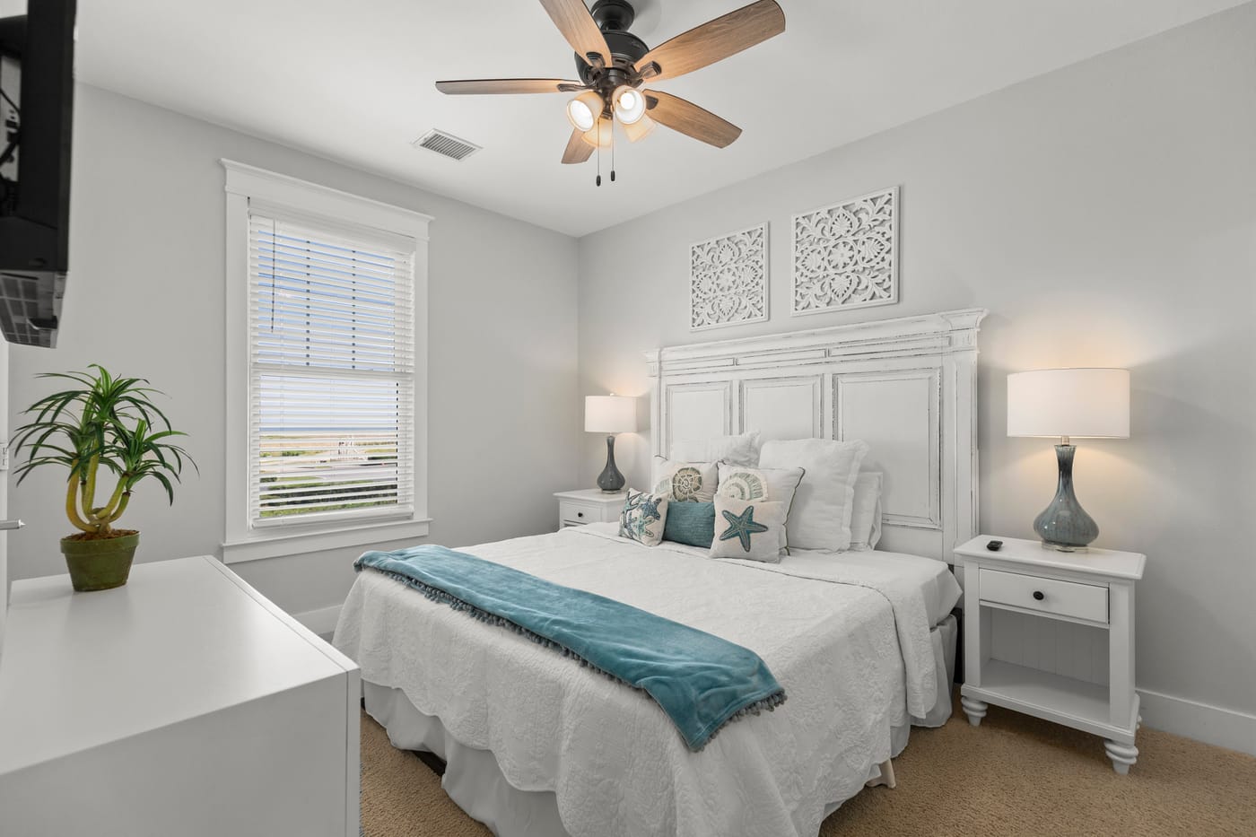 Light-filled guest bedroom with two beds and Gulf views