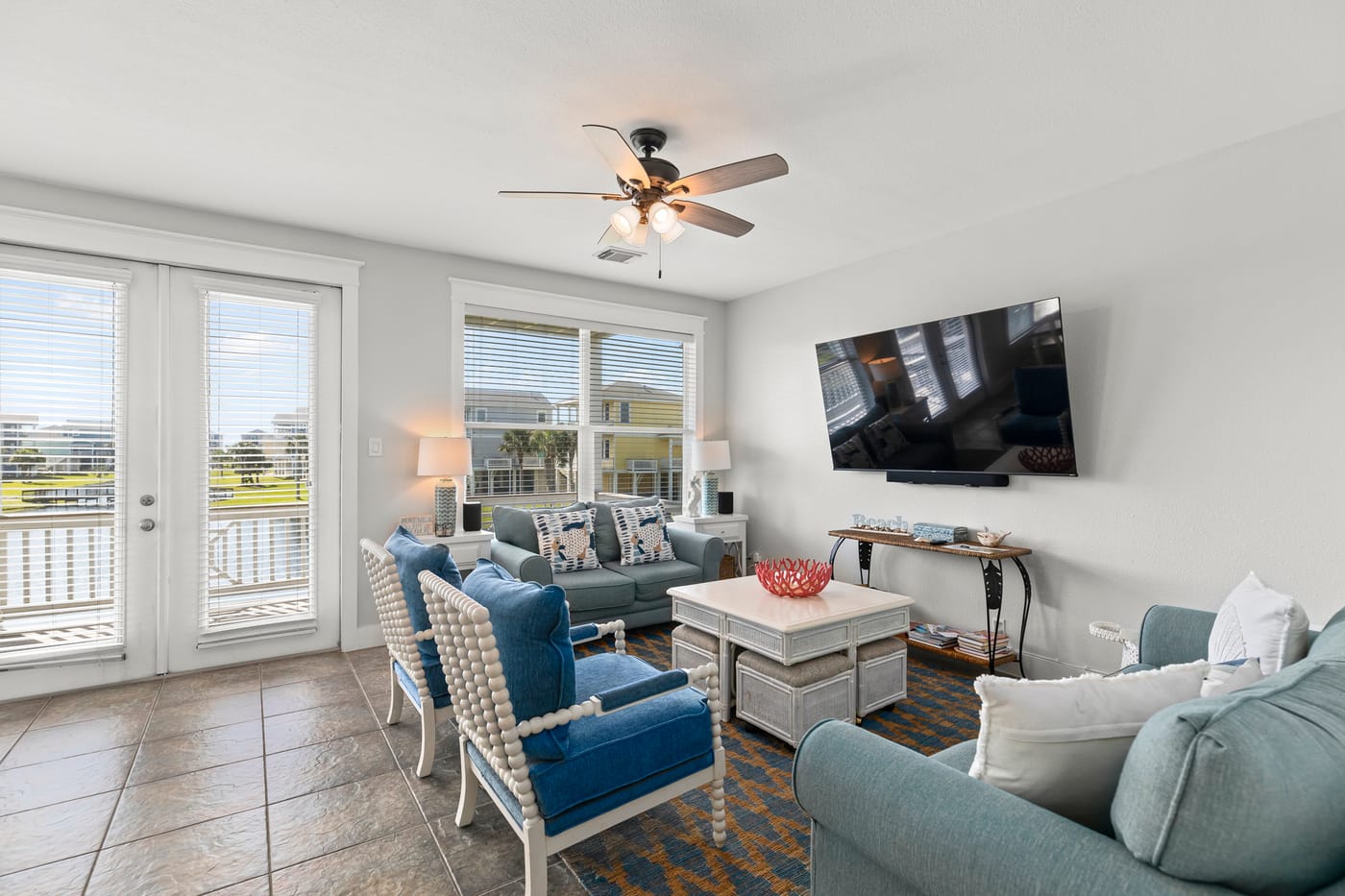 Bright open living room with coastal decor and balcony access